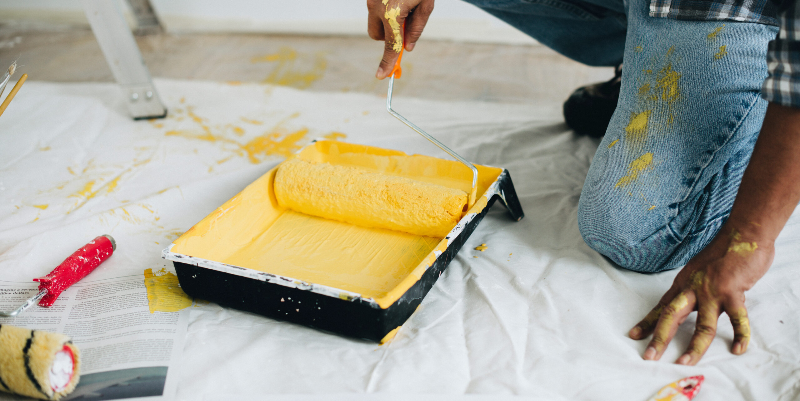 Handyman pouring white paint for home renovation. Couple in apartment flat, repair and makeover